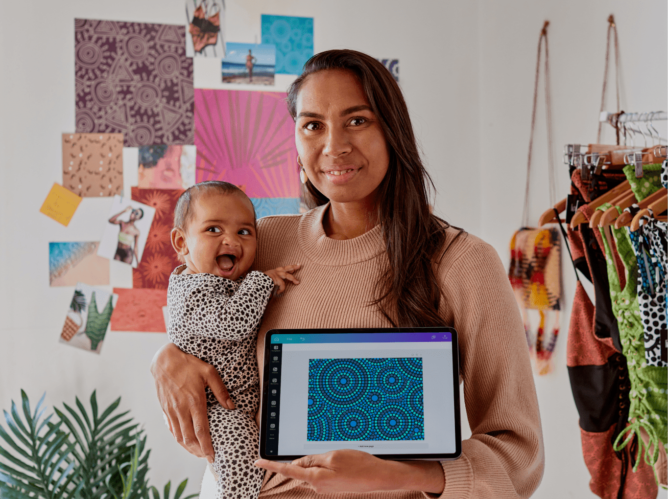 A person holding a baby presenting a design made using Canva